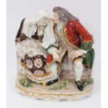 A large 19th century continental porcelain group showing a couple seated on a bench, the gentleman h