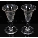 A pair of Georgian ale glasses engraved with hops and barley, on folded foot