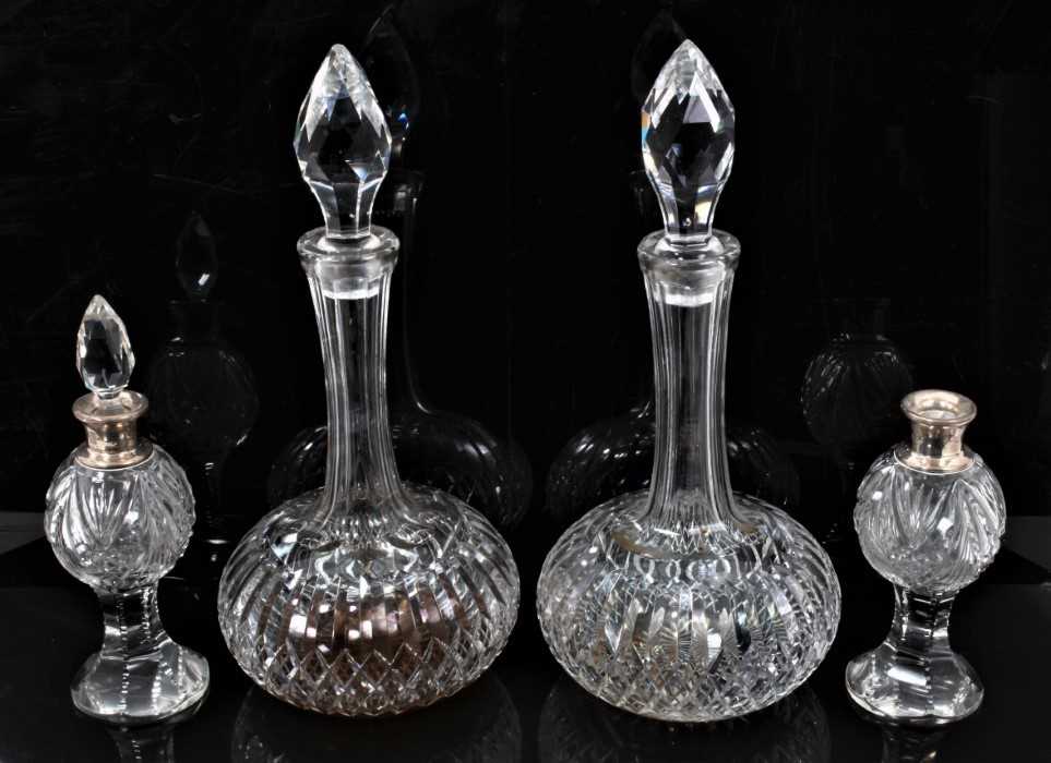 A pair of Webb cut glass shaft and globe decanters, 31cm high, together with a pair of small silver