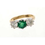 Emerald and diamond three stone ring with a round mixed cut emerald estimated to weigh approximately
