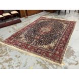 Kashan pattern carpet, with central radiating medallion and scrolling foliate arabesque on midnight