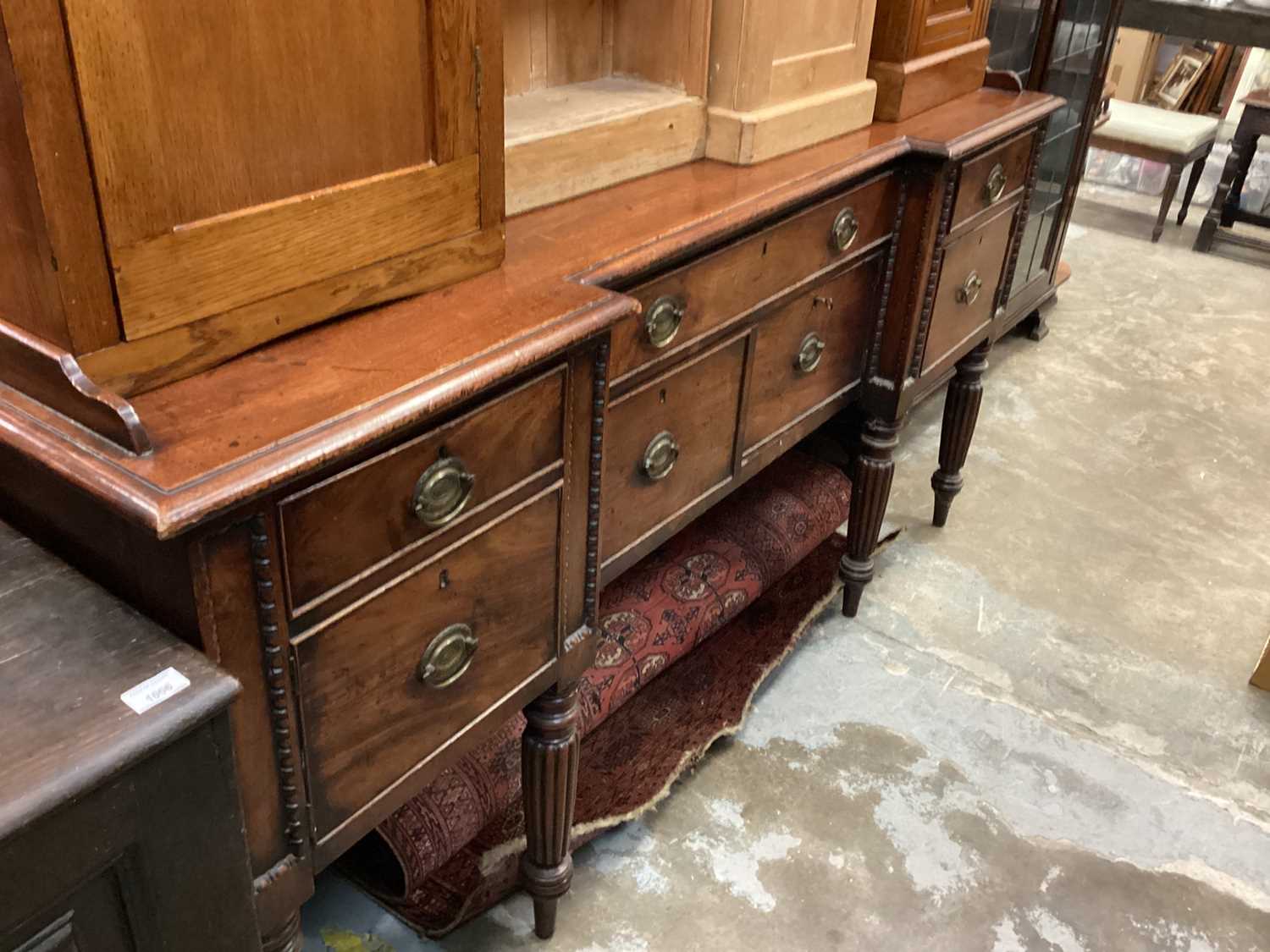 Late Regency mahogany inverted breakfront sideboard with an arrangement of drawers and cupboards on