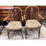 Two 19th century wheelback elbow chairs on turned legs joined by stretchers