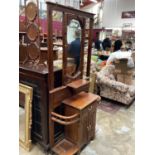 Edwardian walnut hall stand with bevelled mirror back, drawer and cupboards below with carved decora