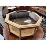 Octagonal coffee table with glass top on turned and block legs with caned undertier, 97cm wide, 43cm