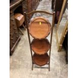Three tier folding cake stand together with an oak occasional table with magazine rack undertier and
