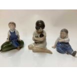 Three Royal Copenhagen porcelain figures - boy on marrow number 4539, girl with doll number 1938 and