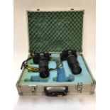 Two Nikon EM 35mm SLR cameras with telephoto lenses, in hard carry case
