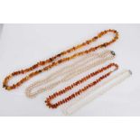 Two amber bead necklaces, cultured pearl necklace with silver clasp and one other simulated pearl ne