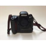 Nikon F5 digital SLR camera body with strap and lens cap
