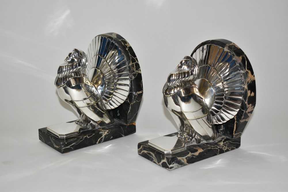 A pair of silvered bronze bookends cast from a model by C. Charles, modelled as fan tailed doves on