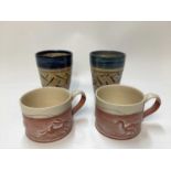 Two studio pottery mugs by Philip Wood and two decorated beakers signed “Still”.