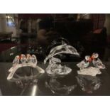 Swarovski crystal Baby Lovebirds on a branch, together with two Puffins on a plinth, and a Dolphin,