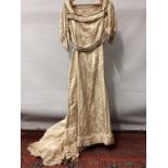 Edwardian evening gown in cream silk with drooping short sleeves and train. Waist, cuffs and neckli