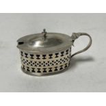 Edwardian silver mustard pot of oval form, with pierced decoration and blue glass liner, (London 190