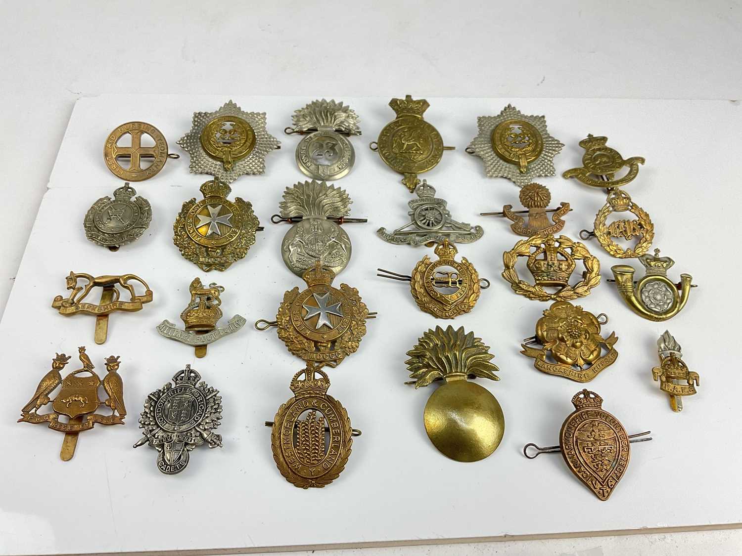 Collection of twenty five British military cap badges to include King's Own Malta Regiment, Royal We