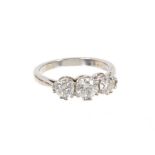 Diamond three stone ring with three round brilliant cut diamonds in claw setting on platinum shank.