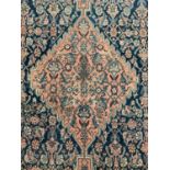 West Persian rug, with central diamond shaped medallion and knot work spandrels on midnight blue gro