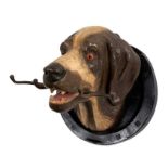 Late 19th/early 20th century painted terracotta hound mask whip holder within a horseshoe, 30cm wide