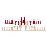 19th century carved and red stained bone chess set, the king 9cm high, in wooden case
