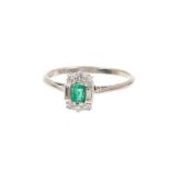 Art Deco emerald and diamond ring with a rectangular step cut emerald flanked by six single cut diam