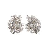 Pair of 1950s diamond earrings, each with a central large old cut diamond surrounded by a scroll des