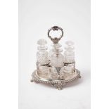 Regency silver cruet of oval form with gadrooned border and four cut glass bottles, acanthus moulded