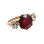 Ruby and diamond three stone ring with an oval mixed cut ruby measuring approximately 12mm x 11.5mm