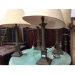 Four matching brass Corinthian column style table lamps and shades