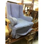 Edwardian wing back armchair with loose blue cover on square taper front legs and castors