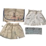 A selection of children's vintage clothing including swimsuits and dresses, two small embroidery sam