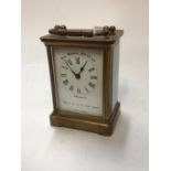 French brass carriage clock with white enamel dial marked "The Reason MFD Co. Ltd." "Keep up with th