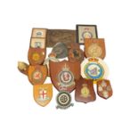 Collection of old military wall plaques including carved and painted wood examples with badges (3 bo