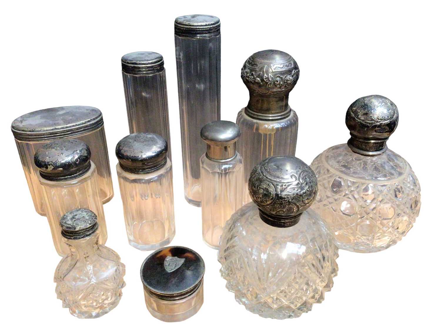 Collection of mostly silver topped glass vanity jars and perfume bottles