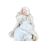 A charming group of three antique dolls together with a facsimile photograph of the original owner (