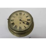 A brass bulkhead clock, white enamel dial, the case 27cm diameter and stamped '8219'
