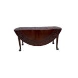 George III mahogany oval gateleg dining table with carved decoration on pad feet