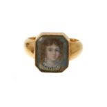 An early 19th century gold portrait ring with a finely painted portrait miniature depicting a young