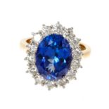 Good quality tanzanite and diamond cluster ring with an oval mixed cut tanzanite weighing approximat