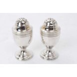 Pair George III silver pepper pots of urn form with pierced slip on covers
