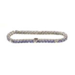Tanzanite and diamond tennis bracelet with 37 round tanzanites totalling 9.37cts interspaced by 6 ro