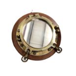 Brass ship's port hole mirror on circular wooden wall mount