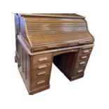 Early 20th century oak roll top desk with tambour shutter, fitted interior and nine drawers below, 1
