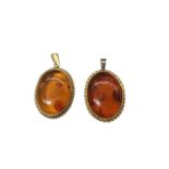 Two 18ct gold mounted oval amber pendants