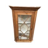 Antique pine corner cupboard with shaped shelves enclosed by astragal glazed door, 70cm wide, 108cm