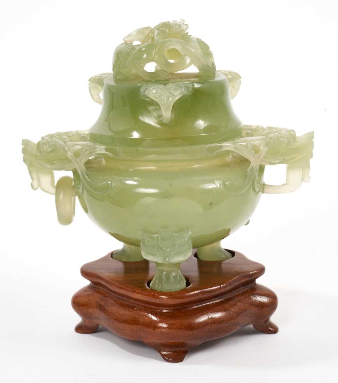 Chinese carved green jade pot and cover on a wooden stand