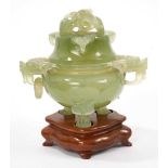 Chinese carved green jade pot and cover on a wooden stand