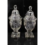 Good quality pair of Regency cut glass covered urns, with swag decoration, on stepped square bases,