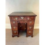 George II walnut and crossbanded and featherbanded kneehole desk, the top with re-entrant angles, ha