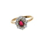 Garnet and diamond cluster ring with an oval mixed cut garnet surrounded by eight brilliant cut di